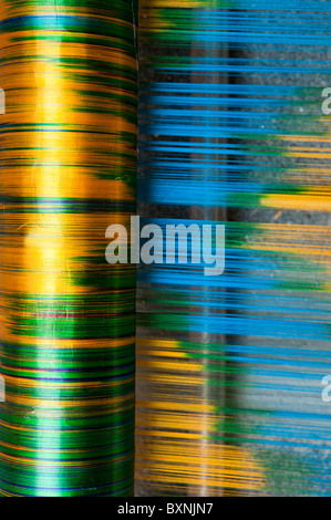 Filo di seta su di un telaio di tessitura a mano facendo un sari di seta in un Indiano cottage. Andhra Pradesh, India Foto Stock