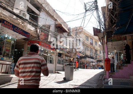 Un uomo curdo a piedi attraverso un vialetto pedonale nel bazaar all'aperto nella città di Duhok, nella regione del Kurdistan, del nord Iraq. Foto Stock