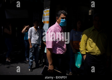 Un uomo che indossa una maschera come precauzione contro l influenza suina Passeggiate in Città del Messico la principale piazza Zocalo, 29 aprile 2009. Foto Stock