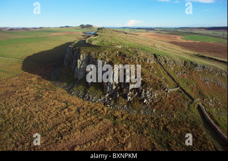 Il Vallo di Adriano in esecuzione sul peel falesie con Highshield balze e roccioso del Lough in background Foto Stock