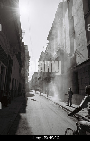 Una scena tipica dell'Avana che guarda su una strada dove c'è stata una certa fumigazione che mostra nuvole di sostanze chimiche che riempiono la strada. Foto Stock