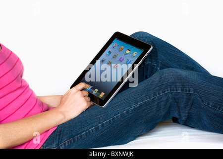 Donna rilassante utilizzando un Mac Apple iPad sul suo grembo. Foto Stock