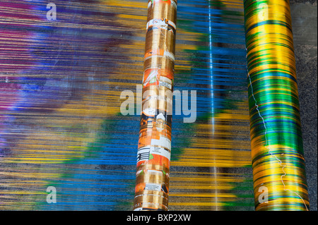 Filo di seta su di un telaio di tessitura a mano facendo un sari di seta in un Indiano cottage. Andhra Pradesh, India Foto Stock
