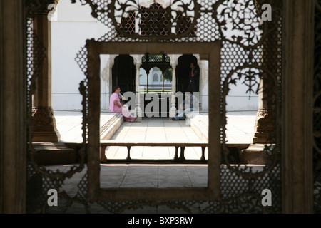 Vista dei turisti di appoggio attraverso archi in marmo e le rotture della struttura a reticolo a Fort rosso Lal Qila, Delhi, India settentrionale Foto Stock