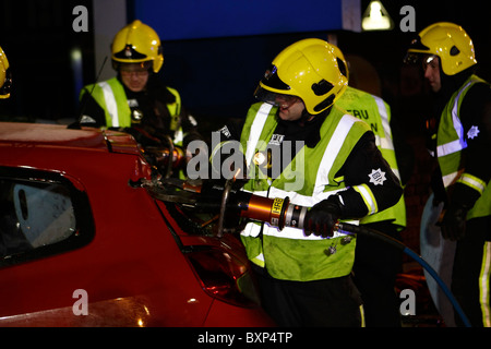 Firefighter utilizzando ganasce della vita Foto Stock