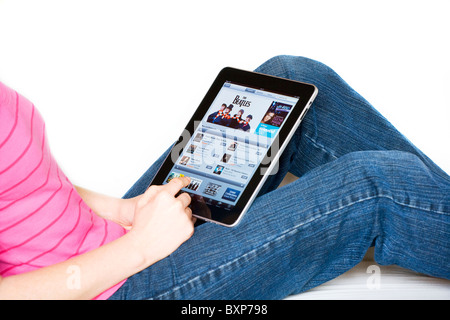 Donna rilassante utilizzando un Mac Apple iPad sul suo giro shopping online presso iTunes Store Foto Stock