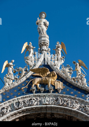 San Marco statua e leone alato sulla sommità della facciata della basilica di San Marco, Venezia, Italia Foto Stock