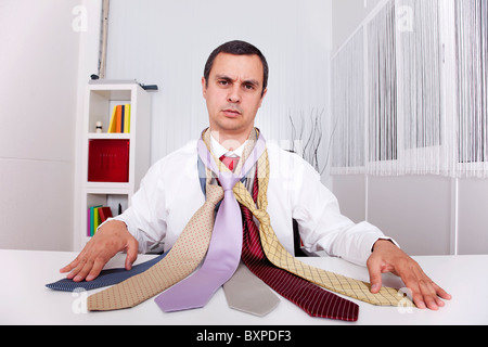 Imprenditore maturo in cerca di un sacco di cravatte, pensando cosa scegliere Foto Stock