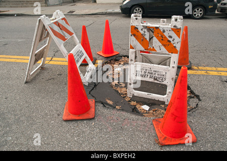 Grandi buche sulla strada causate da heavy rain. Foto Stock