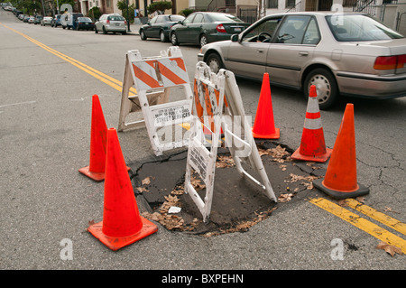 Grandi buche sulla strada causate da heavy rain. Foto Stock