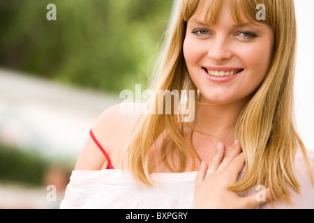 Foto di attraente bionda signora guardando la fotocamera con un sorriso Foto Stock