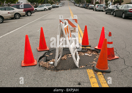 Grandi buche sulla strada causate da heavy rain. Foto Stock