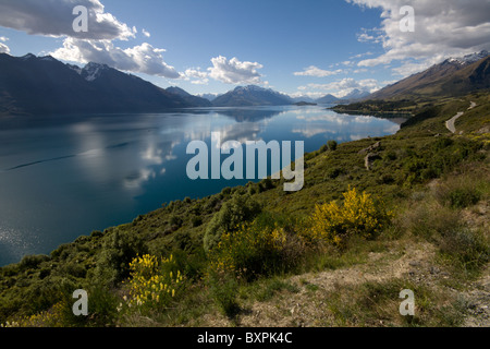 Le montagne e le nuvole si riflettono nelle tranquille acque dell'estremità nord del Lago Wakatipu Foto Stock