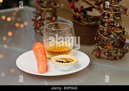 Tritare la torta di carote e bicchiere di whiskey a sinistra su una piastra per la Vigilia di Natale di Babbo Natale e Rudolph Foto Stock