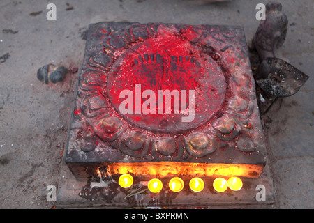 Dipinto di rosso Buddha due piedi vicino al santuario buddista di Swayambhunath in Kathmandu, Nepal in Asia Foto Stock