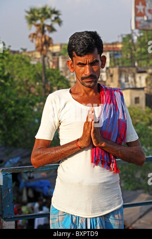 Un uomo indiano che posa con le mani aggrappate in preghiera a Calcutta, India Foto Stock