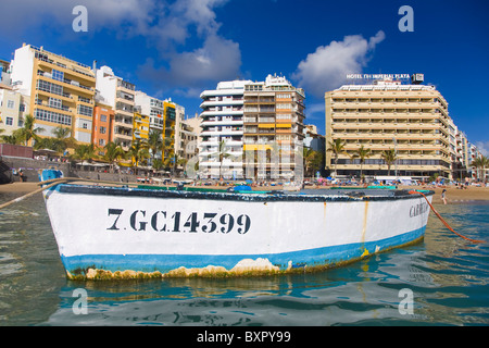 Canteras beach vista dal mare con un legno tradizionale barca da pesca galleggianti in primo piano. Foto Stock