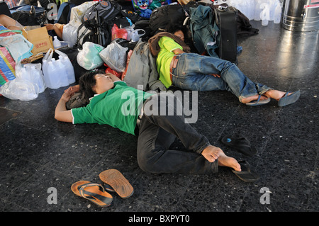 In attesa della gente che dormiva sul pavimento della stazione ferroviaria Foto Stock