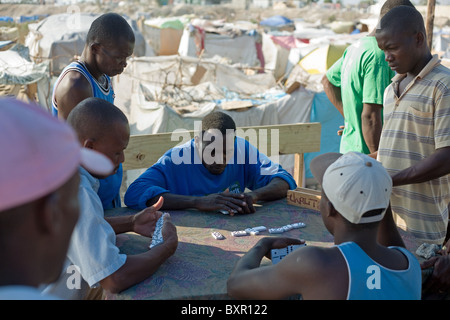 Terremotati GIOCA Domino in un accampamento provvisorio su un sito di discarica a Marassa, vicino a Port-au-Prince aeroporto. Foto Stock