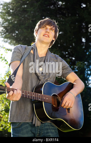 Giovane uomo di suonare una chitarra Foto Stock