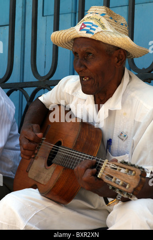 Il vecchio uomo cubano a suonare la chitarra in street band Los Mambises in Plaza de la Catedral. Foto Stock