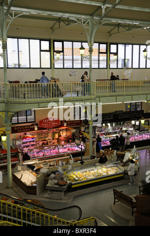 Diario & producono carne va in stallo in una francese mercato coperto shop una panoramica del commerciante e il cliente Town Center Les Sables D'Olonne Foto Stock