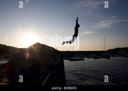 Pier jumping dal porto wall st Mary's isole Scilly, Regno Unito Foto Stock