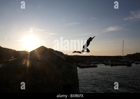 Pier jumping dal porto wall st Mary's isole Scilly, Regno Unito Foto Stock