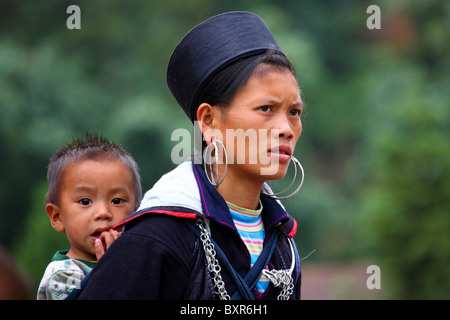 Tribù delle colline di Hmong nero/minoranza etnica femmina con bambino a Sapa, nel nord del Vietnam Foto Stock