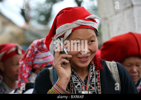 Donna della minoranza etnica Red Dao che parla su cellulare, Sapa, Vietnam Foto Stock