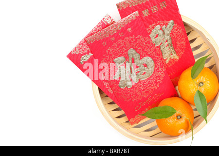 Mandarini arance e pacchetto rosso in bambù vaporiera.carattere sul pacchetto simboleggia fortuna. Foto Stock