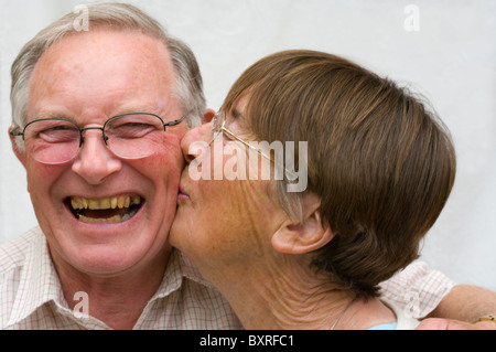 Una vecchia coppia in pensione baciare e coccole Foto Stock