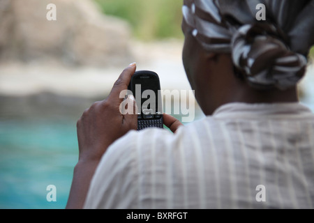 African American donna di scattare le foto con il suo telefono cellulare presso il Bronx Zoo di New York, Stati Uniti, Agosto 4, 2010 © Katharine Andriotis Foto Stock