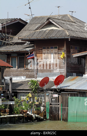 Alloggiamento sgangherato con antenne paraboliche a Bangkok, in Thailandia Foto Stock