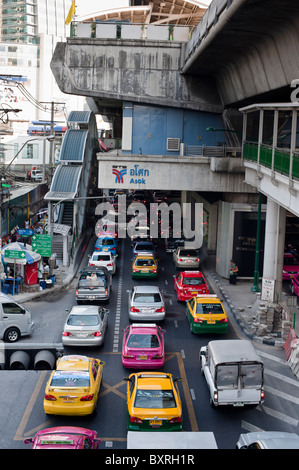 Molti gli inceppamenti di traffico sulla Strada di Sukhumvit Road di Bangkok a destra sotto lo skytrain tracce. Foto Stock