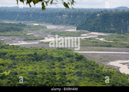 Una vista aerea di un fiume serpeggiante che attraversa un'ampia pianura alluvionale circondata da una fitta foresta verde e ripide scogliere rocciose. Il fiume appare poco profondo con barre di sabbia esposte e multiple Foto Stock