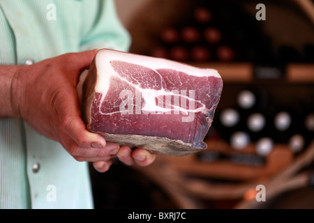 Un macellaio detiene il taglio di carne essiccata presso la norcineria di Val d'Anniviers in Vissoie, Svizzera Foto Stock