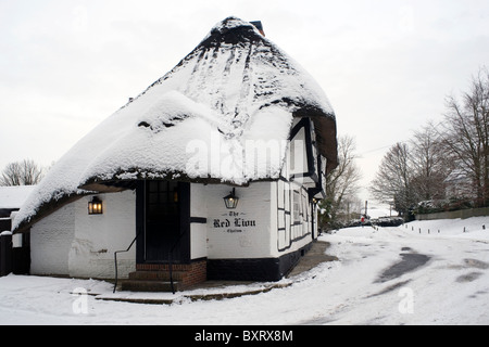 Tradizionali pub con il tetto di paglia nella neve il Red Lion chalton hampshire Inghilterra Foto Stock