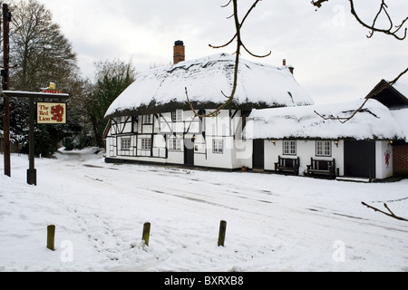 Tradizionali pub con il tetto di paglia nella neve il Red Lion chalton hampshire Inghilterra Foto Stock