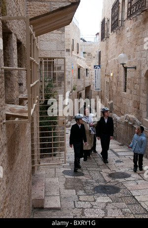 Ebrea ortodossa a piedi di famiglia in una strada del quartiere Jewsish. Gerusalemme la città vecchia Foto Stock