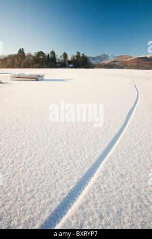 Piste ciclabili attraverso Derwent Water completamente congelato durante il mese di dicembre 2010 Big Chill, Lake District, REGNO UNITO Foto Stock