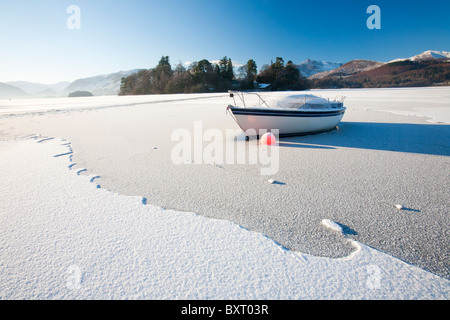 Una barca bloccato nel ghiaccio sulla Derwent Water a Keswick nel distretto del Lago completamente congelato durante il mese di dicembre 2010 big chill Foto Stock