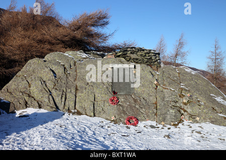 War Memorial lapide con i papaveri sul vertice della rupe del castello in inverno Borrowdale Lake District Cumbria Foto Stock