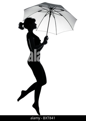 Lunghezza completa silhouette in ombra di una giovane donna di volare con ombrello aperto in studio su sfondo bianco isolato Foto Stock