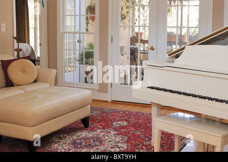 Il modo di vivere moderno sala interna con divano, il lettino, il pianoforte e la visualizzazione della finestra del patio. Foto Stock