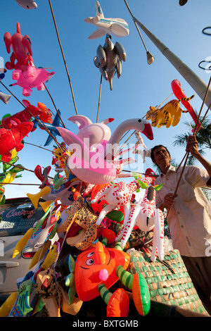 L'uomo dei palloncini di vendita nel mercato, il Delta del Mekong, Chau Doc, Vietnam Foto Stock