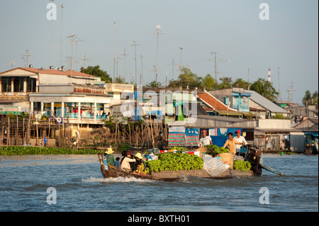 Barca passando le case galleggianti sul Hau Giang River (fiume Bassac), il Delta del Mekong, Chau Doc, Vietnam Foto Stock