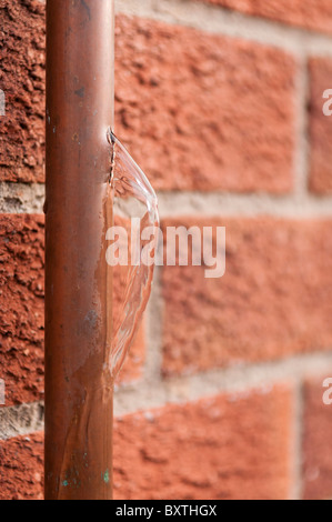 L'acqua uscente da una raffica di rame Tubo di acqua che era stata infranta dal congelamento del ghiaccio. Foto Stock