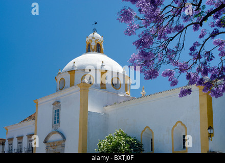 Il Portogallo, Algarve, Tavira Convento de Sao Francisco con alberi di jacaranda in fiore Foto Stock