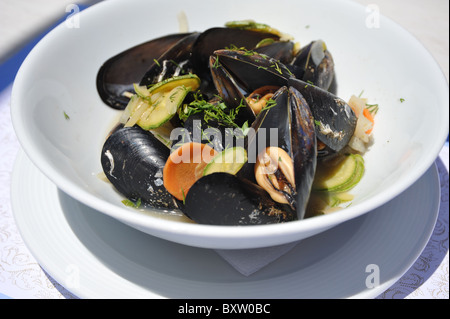 Moules Mariniere - freschi cotti al vapore cozze servite in una ciotola bianco. Foto Stock